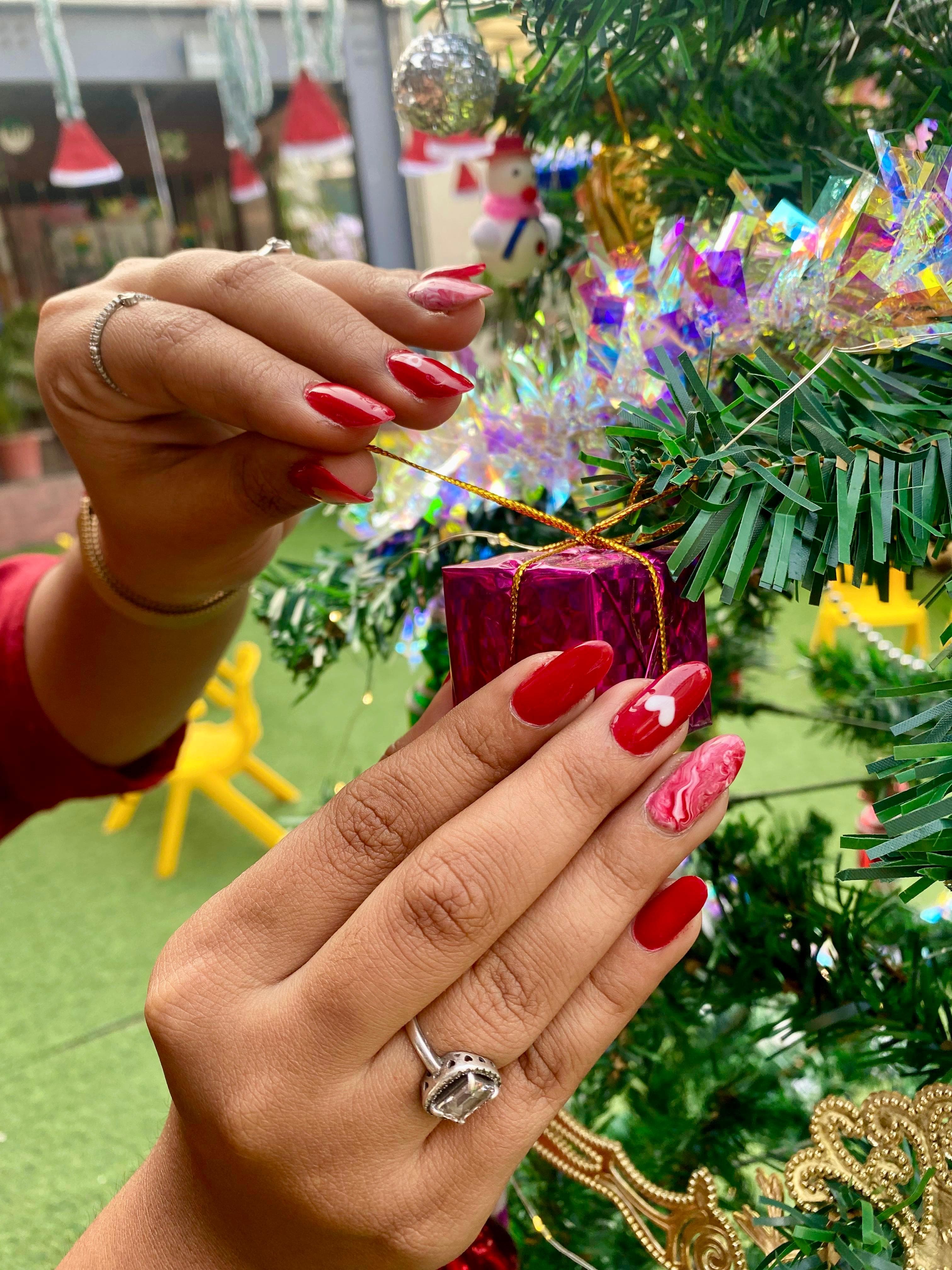 Rich red festive nail art with seasonal styling and detailed accent work