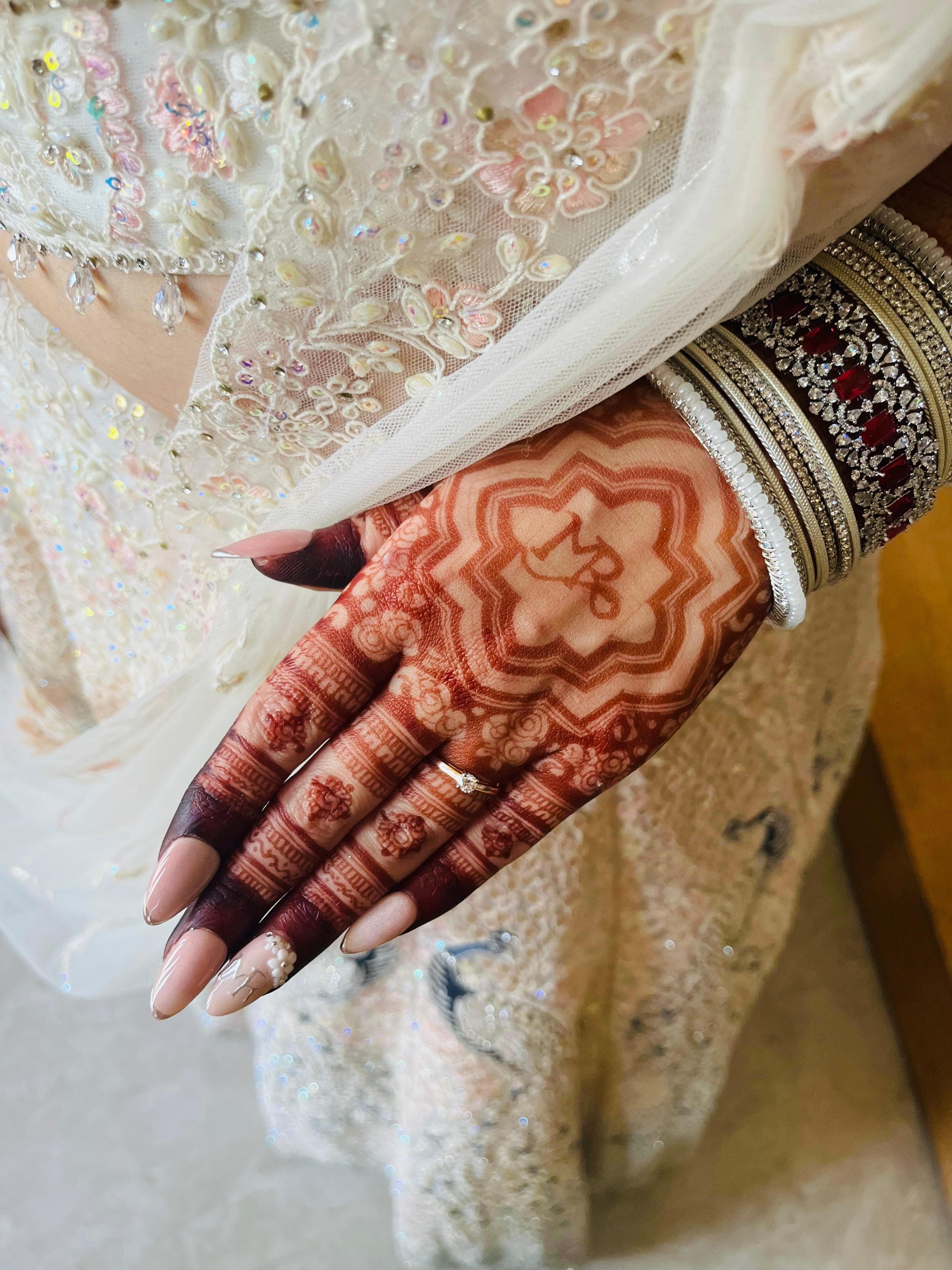 Bridal manicure with pearl nail accents beautifully styled with henna