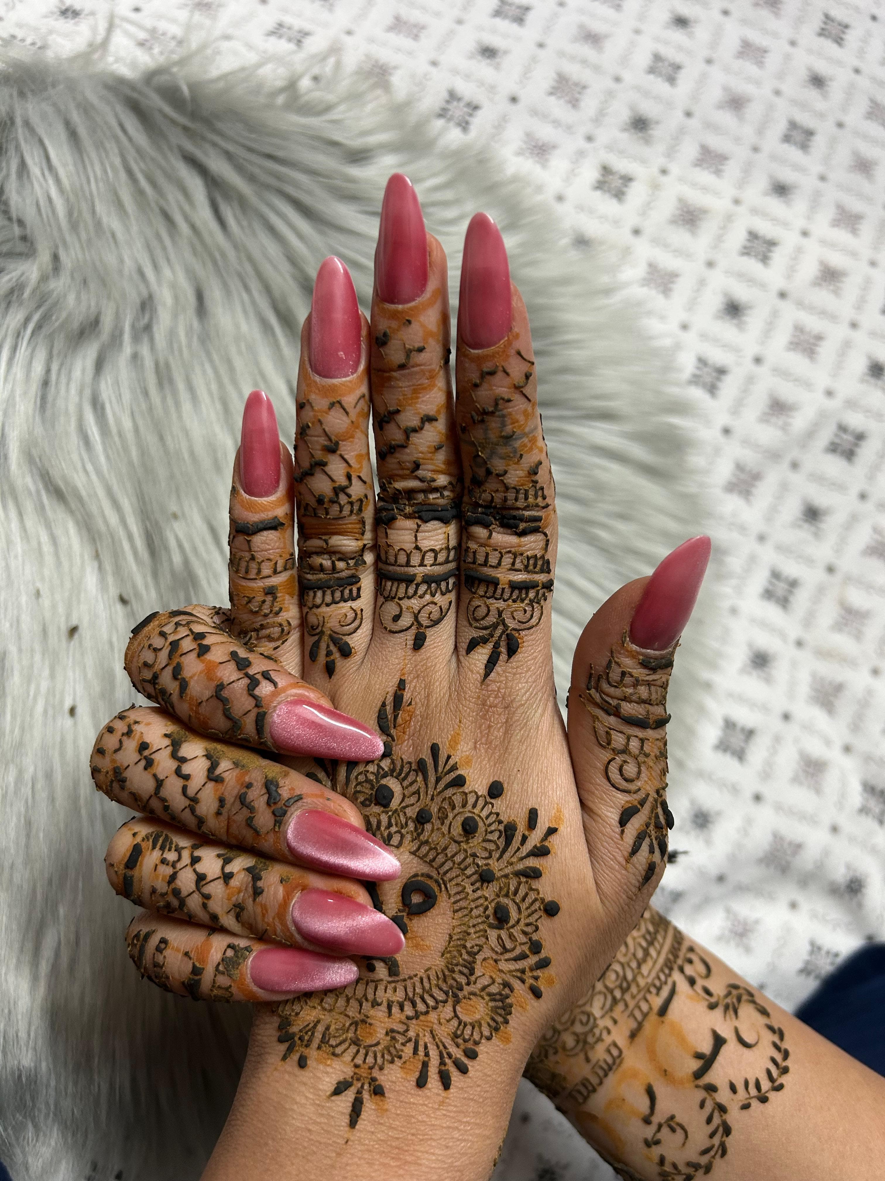 Pink cat-eye gel nails with a luminous shift, paired with bridal henna details